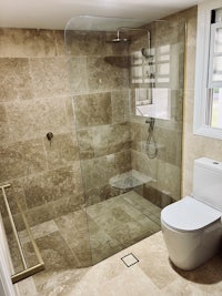 a bathroom with a glass shower stall and toilet